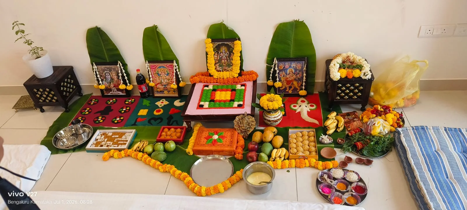 Decorated home puja altar with flowers, fruits and devotional images