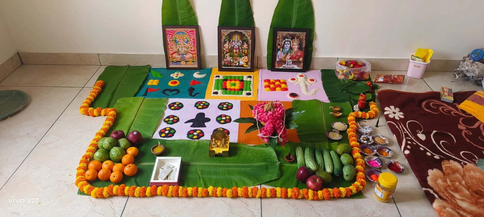 Family puja arrangement with fruits, sweets and devotional images