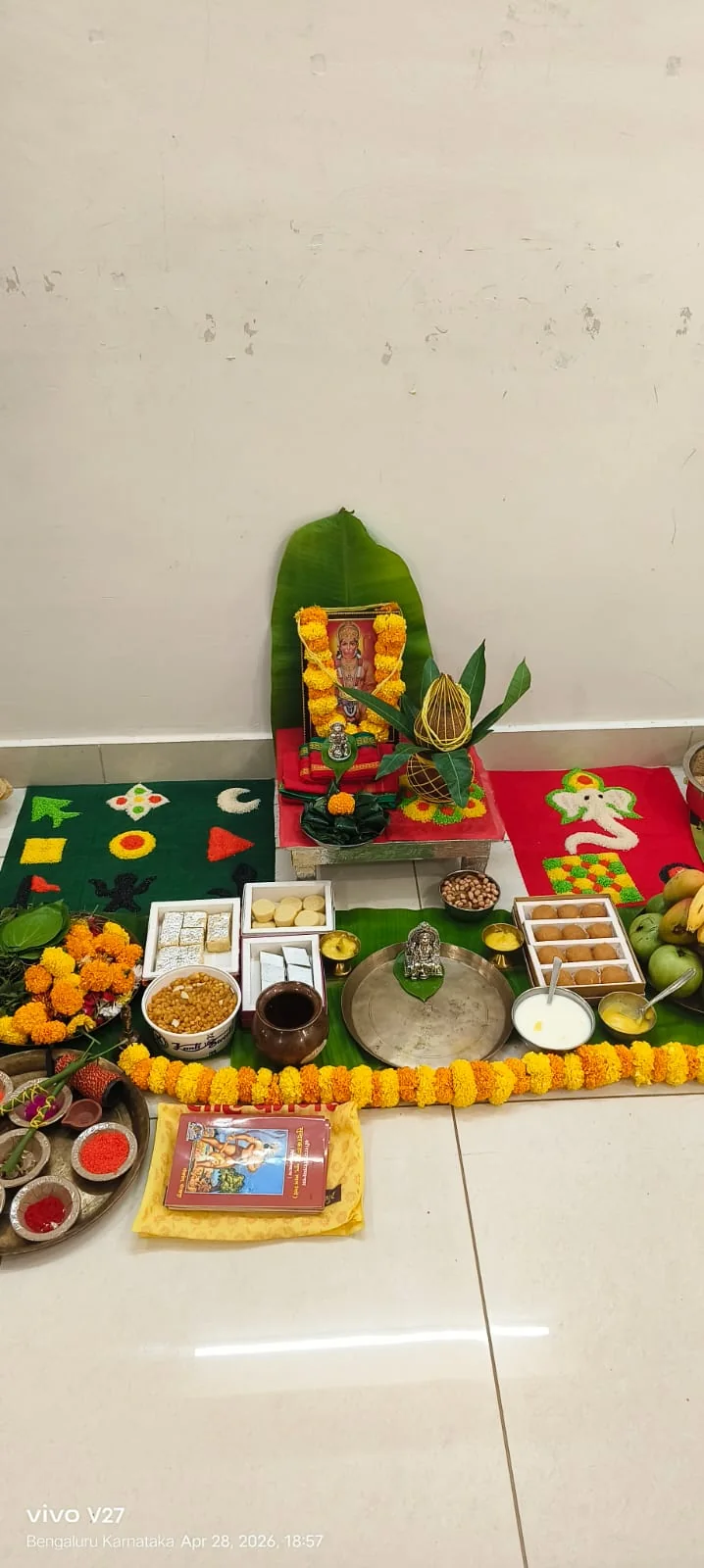 Vertical devotional puja setup with Hanuman image, kalash and sweets
