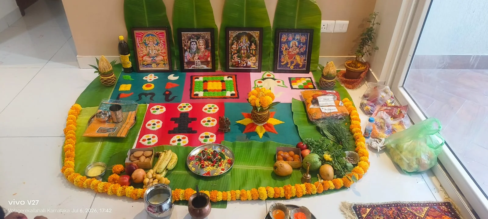 Home puja altar decorated with marigold flowers, banana leaves and devotional images