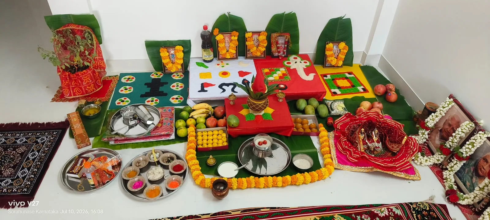 Complete home puja setup with devotional pictures, fruits, sweets and puja materials